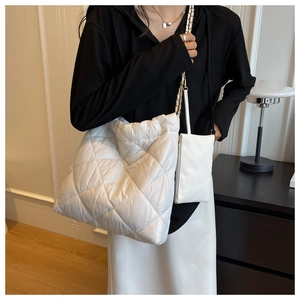 Dettaglio borsa shopper bianca trapuntata con catena dorata e pochette piccola