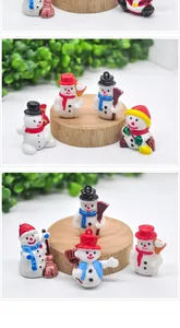 Macro detail of miniature resin snowmen figurines with colorful hats and holiday scarves