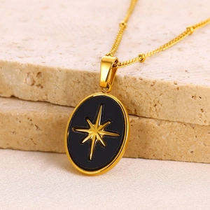 Macro shot of an oval black pendant with a gold star on natural stones