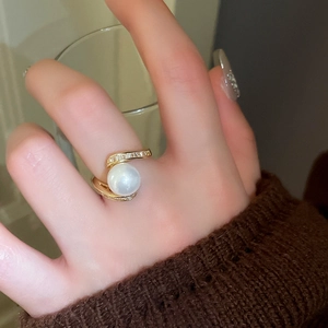 Gros plan d'une bague serpent plaquée or avec une grande perle et des zircons étincelants