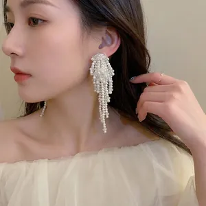 Boucles d'oreilles baroques à pampilles de perles blanches portées par un mannequin