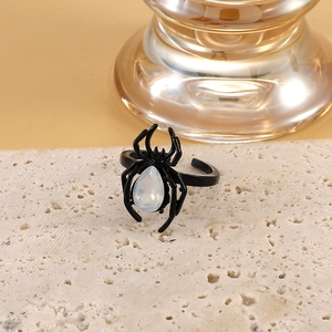 Vintage gothic spider open ring with white teardrop opal stone on natural stone surface