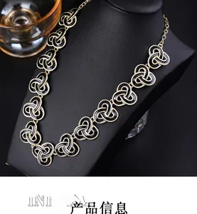 Detail of vintage black enamel necklace with gold geometric pattern on black mannequin