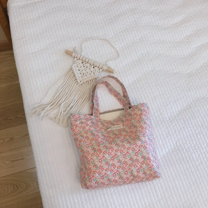 Sac fourre-tout en coton à fleurs avec étiquette sur un fond blanc matelassé élégant