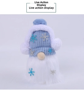 Detail of blue knitted Christmas gnome doll featuring snowflake accents and plush white beard