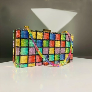 Detail of rainbow rhinestone clutch bag with gold frame and sparkling crystals