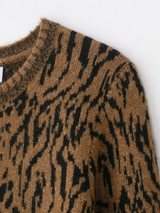 Detailed close-up of tiger stripe knitted sweater with ribbed neckline and premium texture