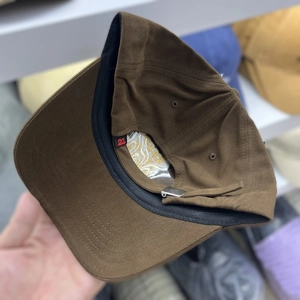 Detail view of cotton baseball cap interior with black sweatband and metal adjustment buckle