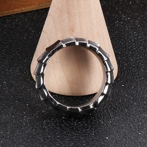 Macro shot of dark stainless steel dragon scale ring with 3D texture and studded diamonds
