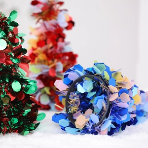 Colorful metallic foil tinsel trees in green, red, and blue for festive holiday decoration