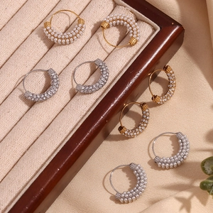 Macro detail of 18K gold plated earrings with micro-inlaid pearls and clear zircons