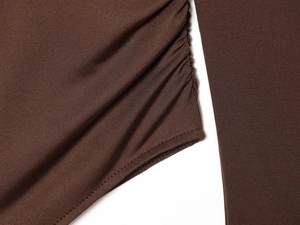 Macro shot of brown nylon bodysuit showing elastic ruching and durable overlock seams