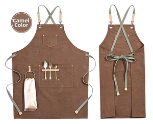 Detailed view of camel canvas apron with leather accents and multiple utility pockets