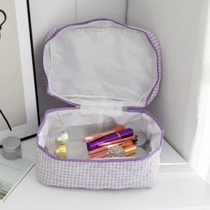 Close-up of a purple checkered quilted cosmetic bag with cosmetics stored inside