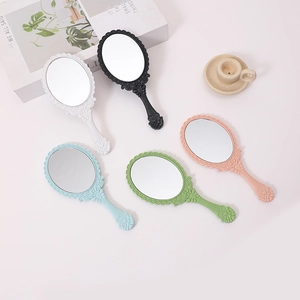Set of five vintage handheld makeup mirrors in pastel colors on a soft pink background