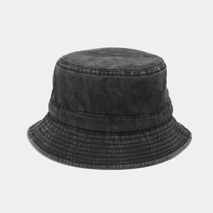 Close-up of distressed washed denim bucket hat with reinforced stitched brim and metal eyelets