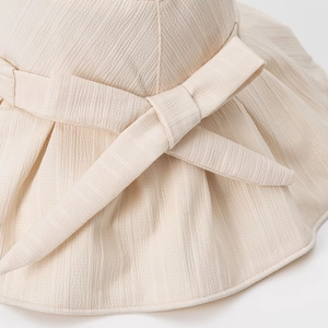 Elegant beige sun hat with textured fabric and large bow detail for women's UV protection