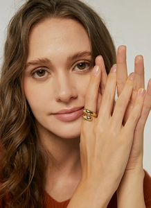 Polished gold double-layer wrap ring worn by model with minimalist aesthetics