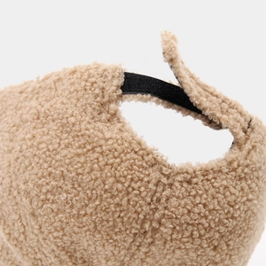 Detail of warm camel sherpa baseball cap featuring an adjustable black strap fastener