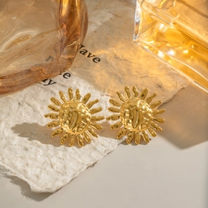 Vintage golden sun stud earrings with hammered texture displayed on a neutral background