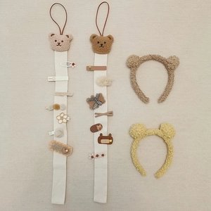 Detail of bear themed hair clip organizer straps and plush headbands for kids' accessories