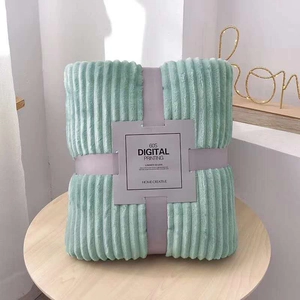 Detail of mint green ribbed flannel blanket folded with elegant paper sleeve packaging
