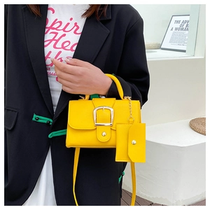 Detail of yellow candy-colored crossbody bag with mini pouch and silver buckle