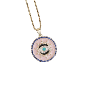 Macro shot of 18K gold plated evil eye pendant with pink enamel and blue crystals