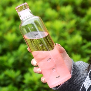 Transparent glass water bottle with time markers and measurement scale for daily hydration