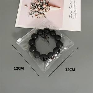 Macro view of clear PVC jewelry storage bag with 12cm black beaded bracelet inside