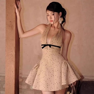 French retro beige polka dot dress with deep V-neck, halter design and black bow accent