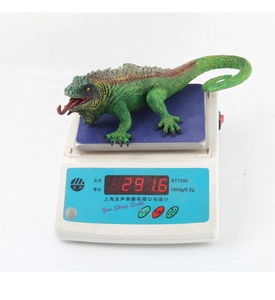 Realistic forest lizard toy model weighing 291.6g on a digital scale tool