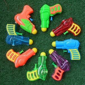 Set of eight colorful mini plastic water guns for outdoor beach play on green grass