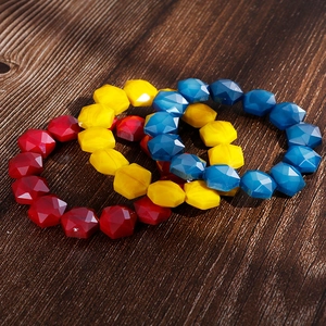 Detail of colorful faceted crystal bead bracelets in red yellow and blue on wood