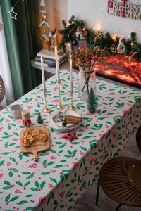 Detailed view of Christmas tablecloth fabric with holly leaves and red berry pattern