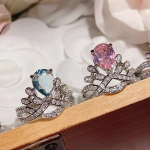 Close-up of crown rings with blue and pink pear-cut gemstones and 18K gold plating