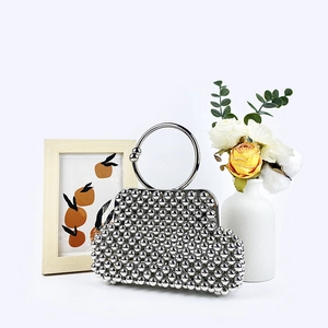 Detailed view of silver beaded evening bag with ring handle and modern pearl texture