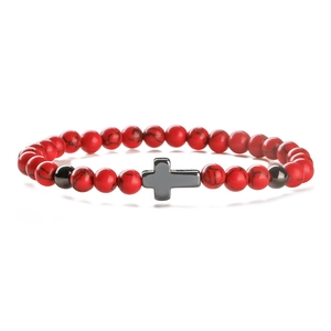 Bracelet en pierres naturelles rouges 6mm avec breloque croix sur fond blanc