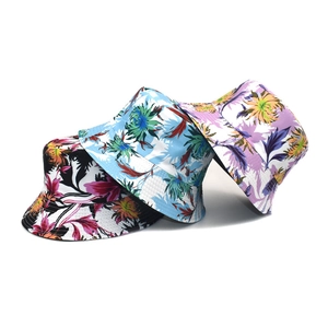 Three reversible tropical floral bucket hats in blue, black, and purple on white background