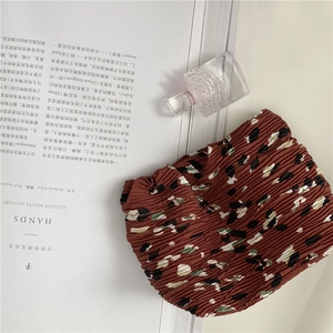 Detailed macro view of the textured pleated chiffon fabric with brown floral pattern