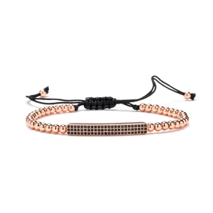 Bracelet ajustable en perles or rose avec barre sertie de zircons noirs sur cordon noir