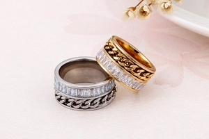 Detail of gold and silver chain rings featuring cubic zirconia and stainless steel finish
