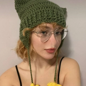 Detail of green handmade crochet cat ear hat with yellow sunflower hanging ornaments