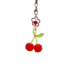 Handmade beaded cherry keychain with red crystals and silver flower clasp on white background