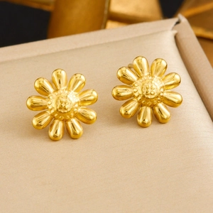 Minimalist gold daisy stud earrings set with a polished metallic finish on a display pad