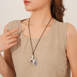 Silver unicorn pendant with blue and white bead tassels on a long brown cord necklace