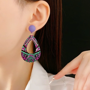 Gros plan sur des boucles d'oreilles bohèmes colorées en forme de goutte