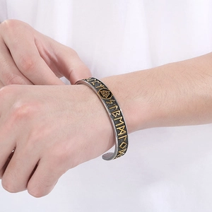 Detail of Viking Valknut cuff bracelet with golden Odin runes on stainless steel