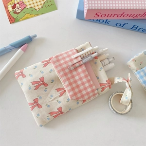 Floral nurse pocket organizer with pink bow and ribbon on a white desk setup