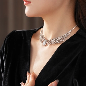 Close-up of elegant silver teardrop necklace with diamond pendant on model neck